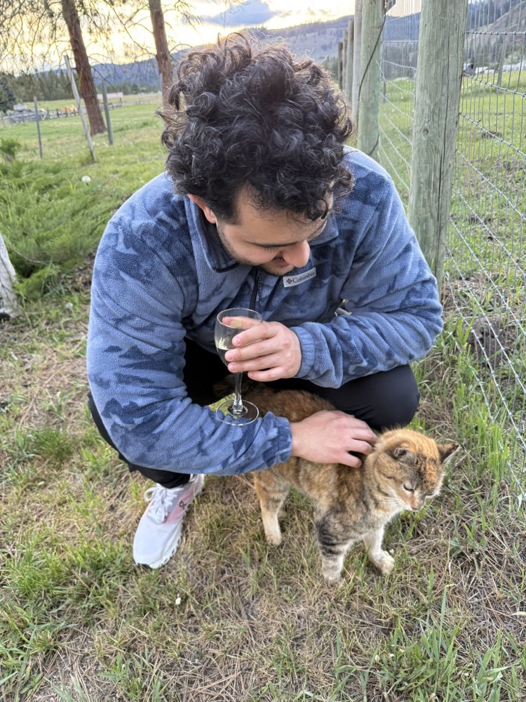 Kaveh making friends with a cat outdoors